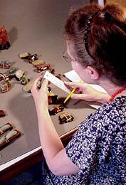Jean Meisner measuring Chinese antique figurines